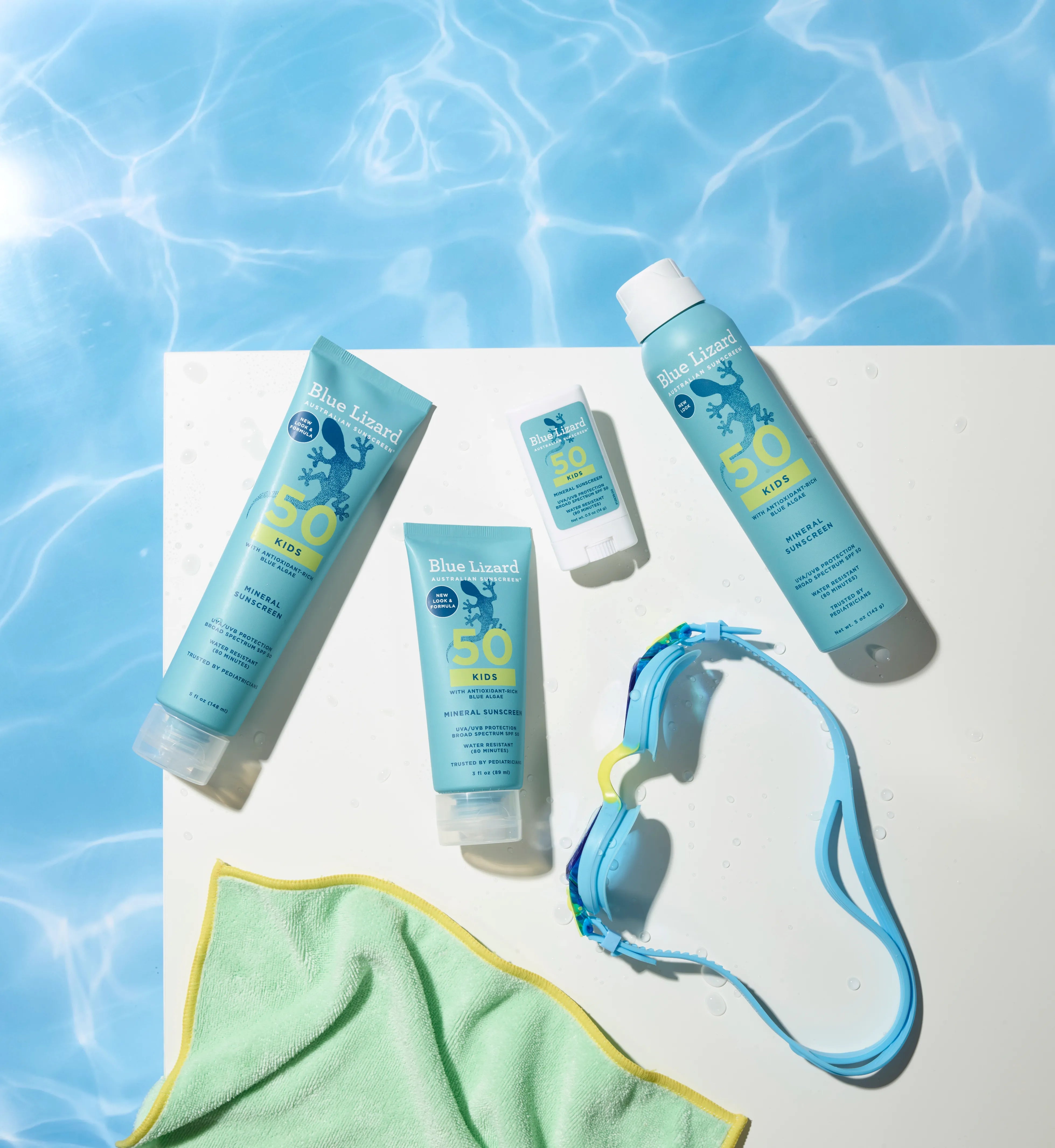 Blue Lizard sunscreen Kids collection next to the swimming pool with a towel and goggles