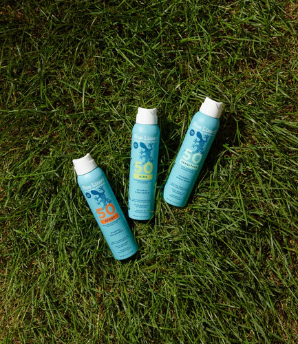 Blue Lizard sunscreen sprays on the grass