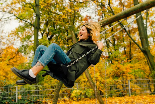 A happy woman on a swing in the fall