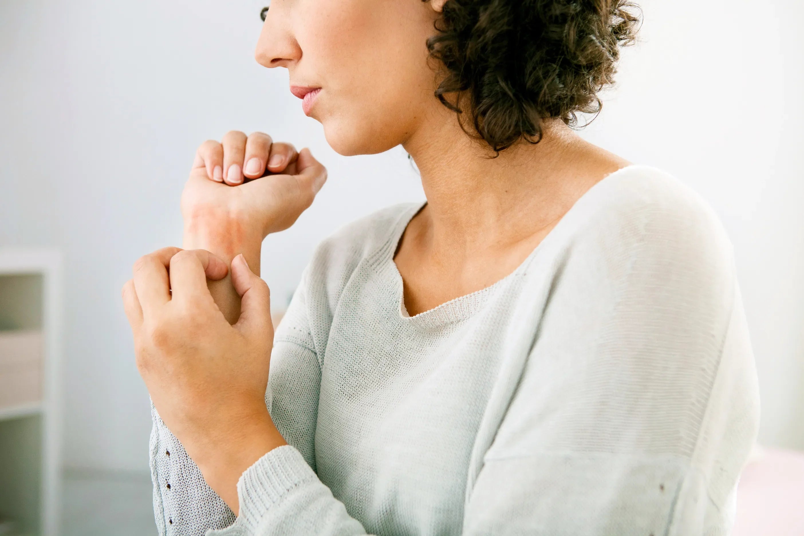 Woman scratching an itchy wrist