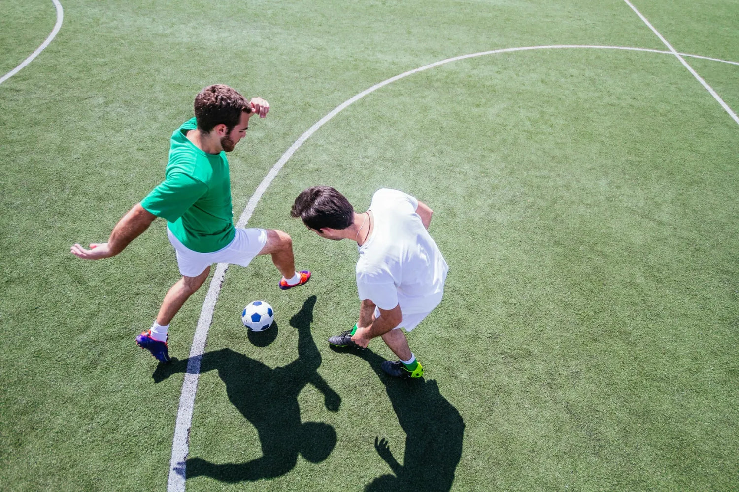 Two people playing soccer outdoors