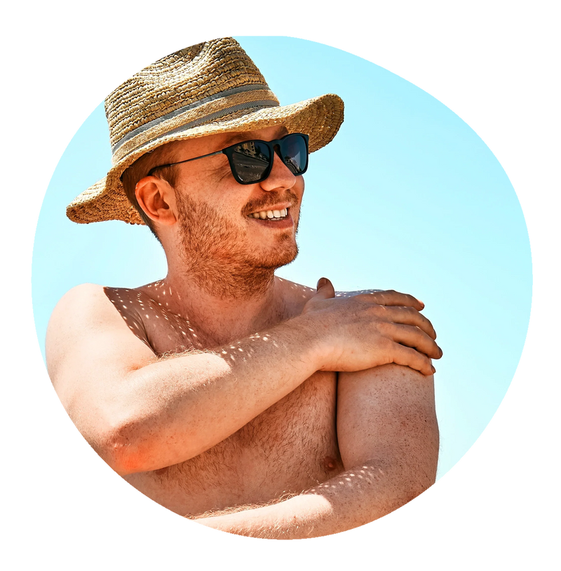 A man in a sun hat and sunglasses applying Blue Lizard sunscreen