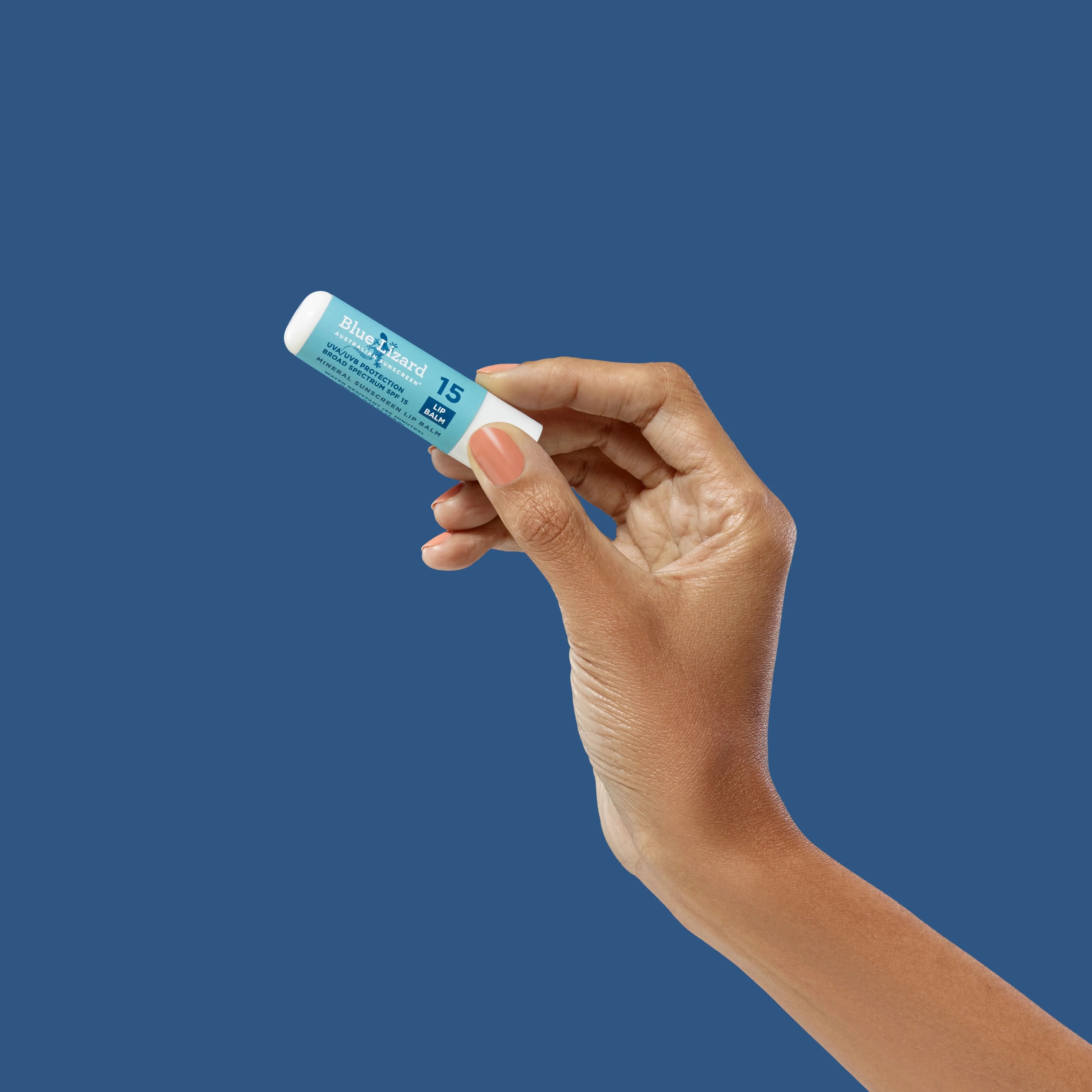 Hand holding Blue Lizard mineral sunscreen SPF 15 lip balm