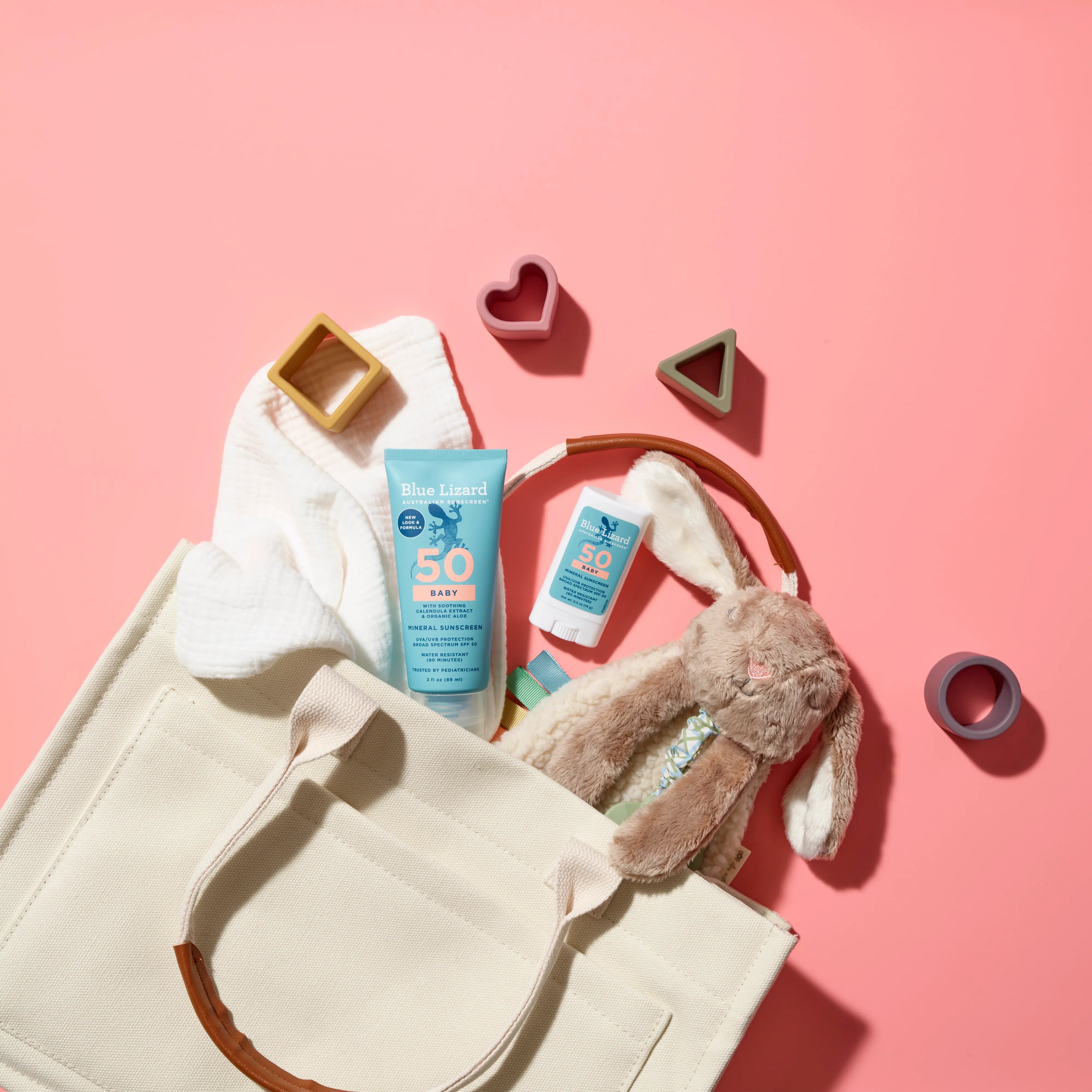 A tote bag with toys and Blue Lizard mineral sunscreen SPF 50 in lotion and stick format