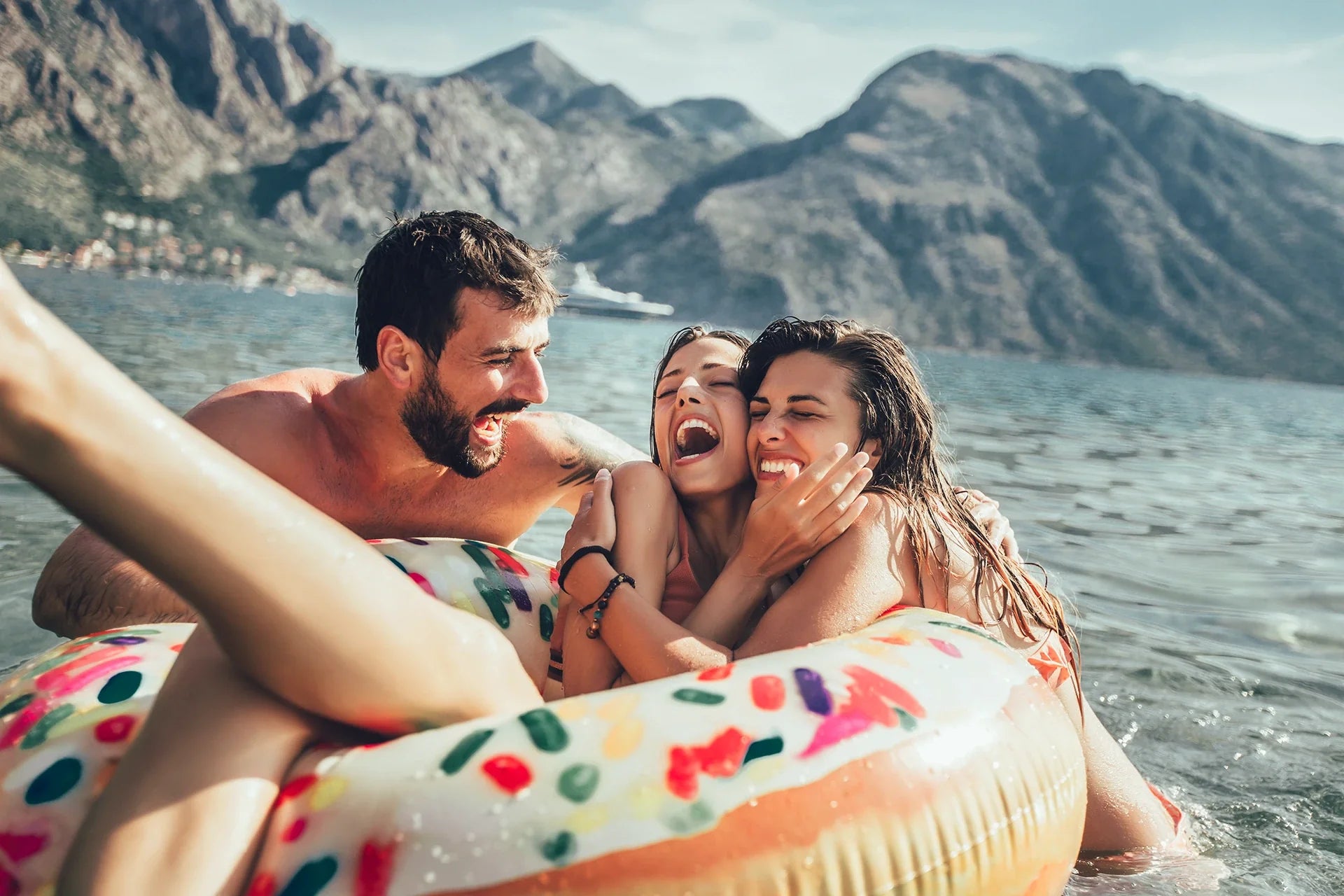 People playing in the water on an inflatable pool donut