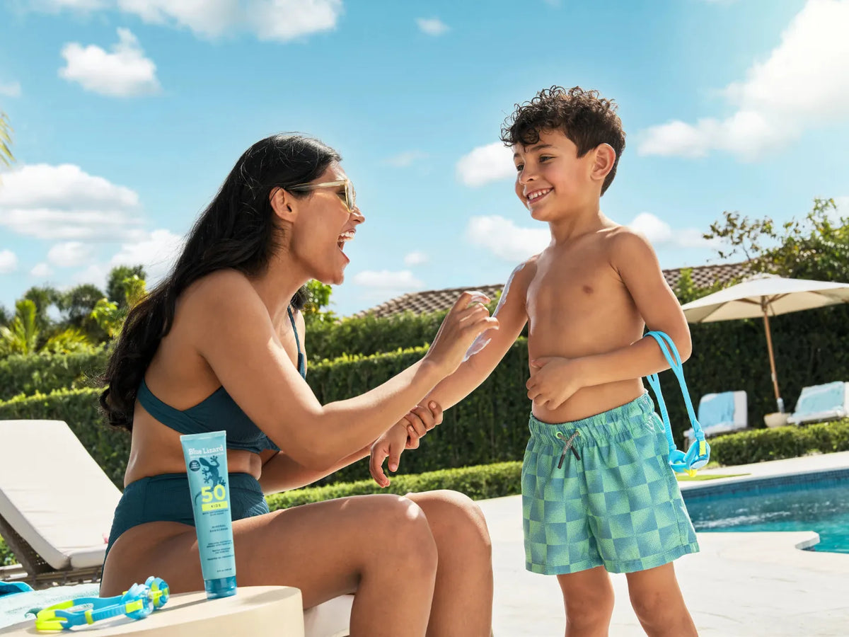 Woman applying sunscreen to a child by a pool