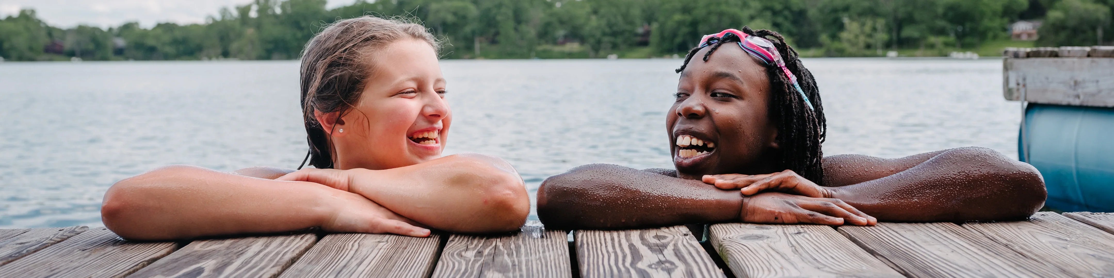 Two women smiling on a dock after swimming