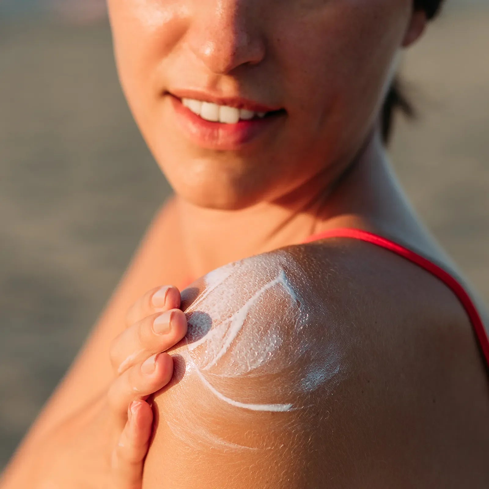 A woman applying Blue Lizard sunscreen on her shoulder